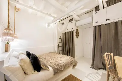 a bedroom with white walls and a bed with pillows at Trastevere Gem Cozy Light-filled Retreat in Rome