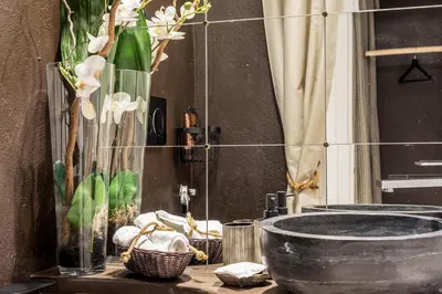 a bathroom with a sink and a vase of flowers at Trastevere Gem Cozy Light-filled Retreat in Rome