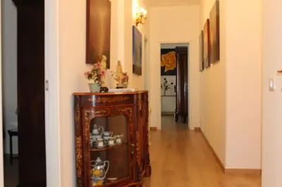 a hallway with a wooden cabinet with flowers on it at ART APARTMENT VILLA FIORELLI in Rome