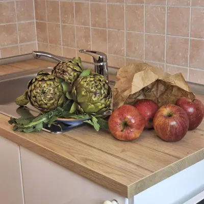 a wooden cutting board with apples and pineapples on it at ART APARTMENT VILLA FIORELLI in Rome