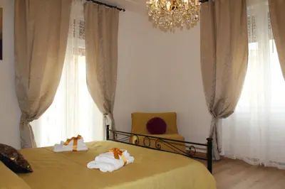 a bedroom with a bed and a chair and a chandelier at ART APARTMENT VILLA FIORELLI in Rome