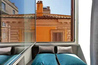 a window with two blue pillows on a balcony at Roma Five Suites in Rome