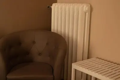 a chair next to a radiator next to a stool at Sogno di un'epoca in Rome