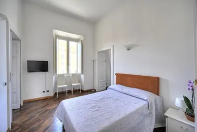 a white bedroom with a bed and a television at Rome Luxury House - The House in Rome