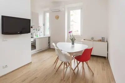 a white dining room with a white table and chairs at Rome Lotto31 Apartment Garbatella in Rome