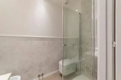 a bathroom with a glass shower with a toilet at Loft Farnese soggiorno 2 stanze 2 bagni luxury centro in Rome