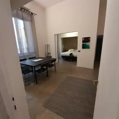a room with a dining table and a bedroom at Loft Farnese luxury 3 stanze 3 bagni salotti cucina in Rome