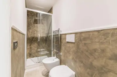 a bathroom with a white toilet and a shower at Loft Farnese luxury 3 stanze 3 bagni salotti cucina in Rome