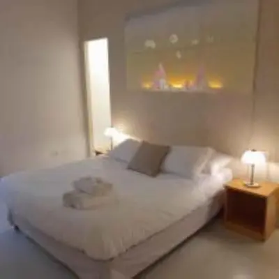 a bedroom with a white bed with two lamps at Loft Farnese luxury 3 stanze 3 bagni salotti cucina in Rome
