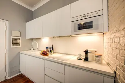 a kitchen with white cabinets and a microwave at Capo Le Case Home 9 in Rome