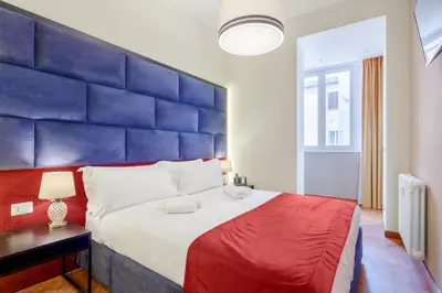 a bedroom with a large bed with a blue headboard at HT HOMETOWN VITE in Rome