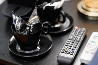 a table with two cups of coffee and a remote control at HT HOMETOWN VITE in Rome