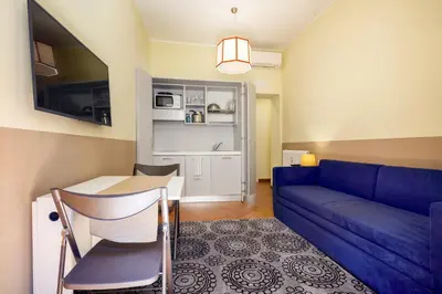 a living room with a blue couch and a table at HT HOMETOWN VITE in Rome