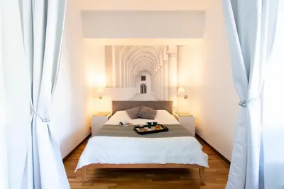 a bedroom with a large bed with white walls at Eva's house Roma in Rome