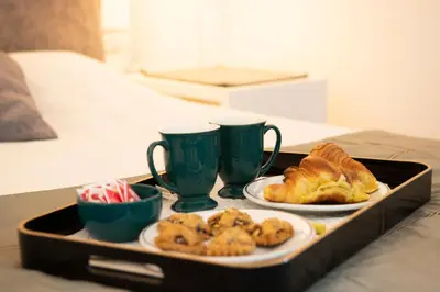 a tray with two cups and pastries on a bed at Eva's house Roma in Rome