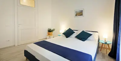a bedroom with a large bed with blue pillows at Pompeo Magno White Luxury Apartment in Rome