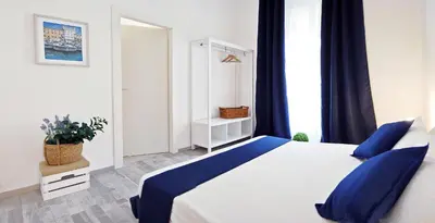 a bedroom with a large bed with blue pillows at Pompeo Magno White Luxury Apartment in Rome