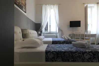 a bedroom with two beds and a window at Vatican Room and Kitchen in Rome