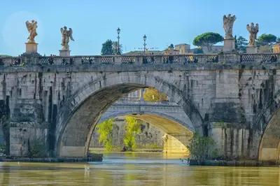 a bridge over the water with statues on it at Vatican Room and Kitchen in Rome