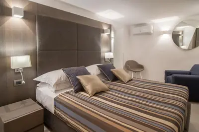a bedroom with a large bed and a chair at Wellness Home Rome in Rome