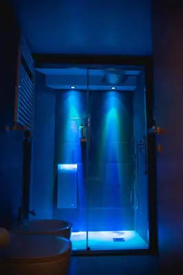 a bathroom with a glass shower with a blue light at Wellness Home Rome in Rome