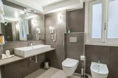 a bathroom with a sink and a toilet and a mirror at Wellness Home Rome in Rome