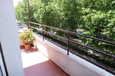 a balcony with a railing on a building with trees at CASA ARIEL in Rome