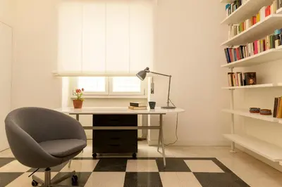 a desk with a chair and a lamp in a room at Virgiliano Apartment in Rome