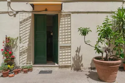a green door on a building with potted plants at Virgiliano Apartment in Rome
