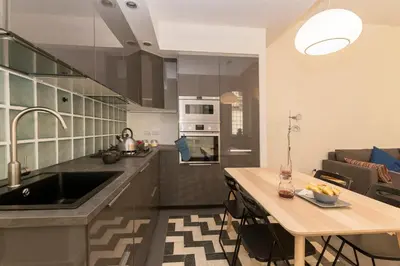 a kitchen with a sink and a table in a room at Virgiliano Apartment in Rome