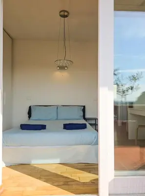 a bedroom with a bed with blue pillows on it at Panoramic Sunset Terrace Attic in Rome