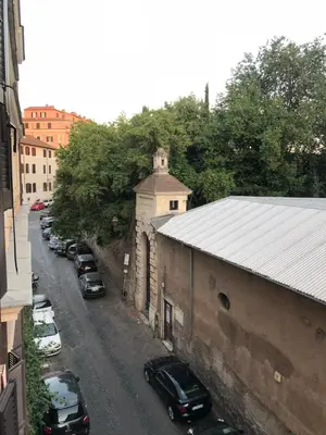 a street with cars parked on the side of a building at COLOSSEUM STREET HoMe in Rome