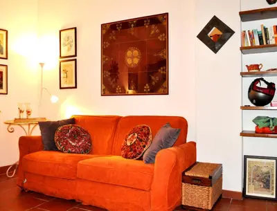 an orange couch sitting in a living room at Roman Atmospheres in Rome