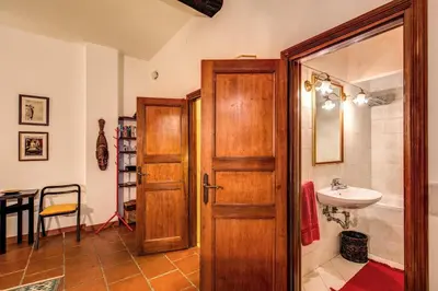 a bathroom with a wooden door and a sink at Roman Atmospheres in Rome