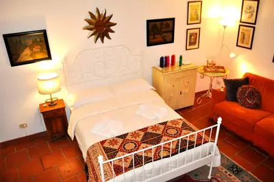 a bedroom with a white bed and a red couch at Roman Atmospheres in Rome