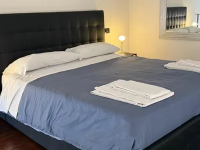 a bed with two white towels on top of it at ROME LUXURY HOUSE - THE SUITE in Rome