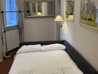 a bed in a room with a lamp and a mirror at ROME LUXURY HOUSE - THE SUITE in Rome