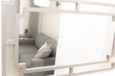 a living room with a gray couch and a mirror at Domus Termini in Rome