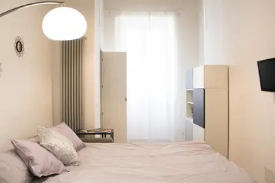 a bedroom with a bed with pink pillows at Domus Termini in Rome
