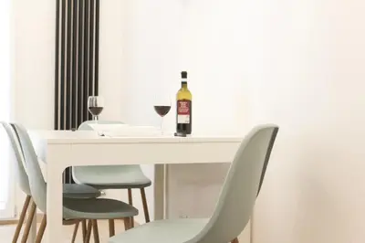 a white table with a bottle of wine and chairs at Domus Termini in Rome