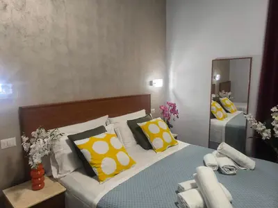 a bedroom with a bed with yellow and white pillows at Napoleone Luxury Home roma in Rome