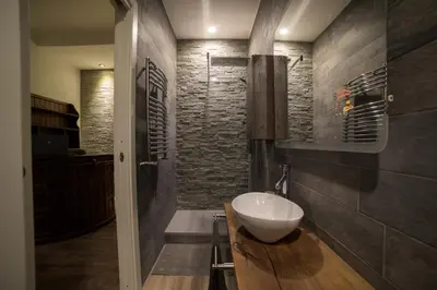 a bathroom with a bowl sink on a wooden counter at Malenki in Rome