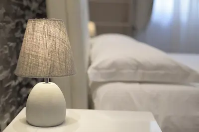 a white lamp sitting on a table in a bedroom at Malenki in Rome