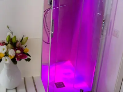 a pink shower in a room with a vase of flowers at The Right Place - Guest House in Rome