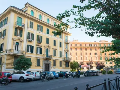 a large building with cars parked on the side of a street at The Right Place - Guest House in Rome