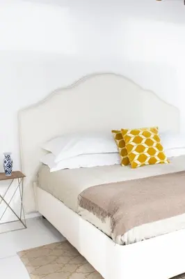 a white bed with yellow and white pillows at Casa Pietra in Rome