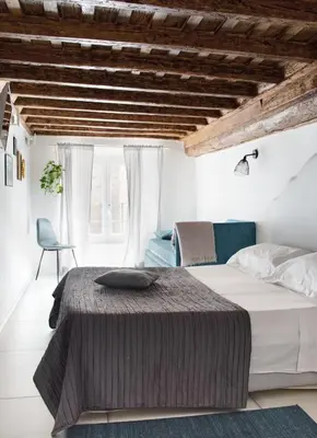 a bedroom with a bed and a chair at Casa Pietra in Rome