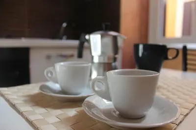 two cups sitting on a counter with a coffee maker at Riari 59 Rome Trastevere - Rome Vacation M&D in Rome