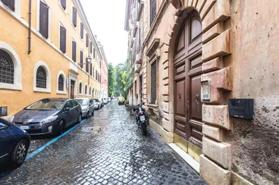 a cobblestone street with cars parked on the side of buildings at Riari 59 Rome Trastevere - Rome Vacation M&D in Rome