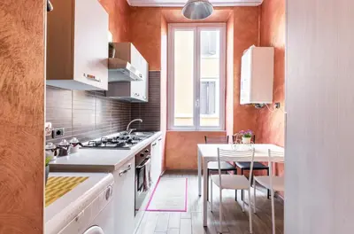 a kitchen with white appliances and a table with chairs at Riari 59 Rome Trastevere - Rome Vacation M&D in Rome